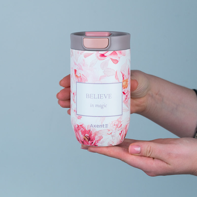 Kubek termiczny Axent 350 ml z motywem piwonii trzymany w dłoniach.