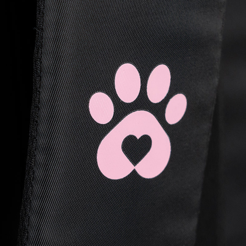 Zbliżenie na uroczy print w kształcie łapki umieszczony na fakturze tkaniny bouclé.