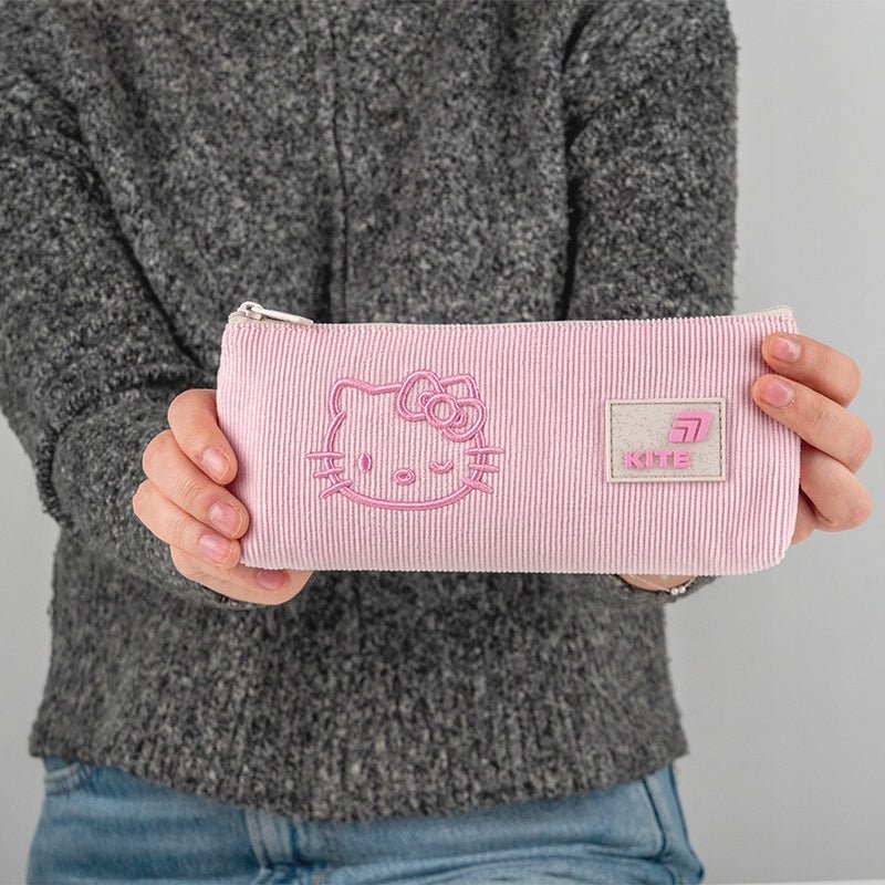 Dziewczynka trzymająca różowy piórnik dla dziewczynki z licencją Hello Kitty.