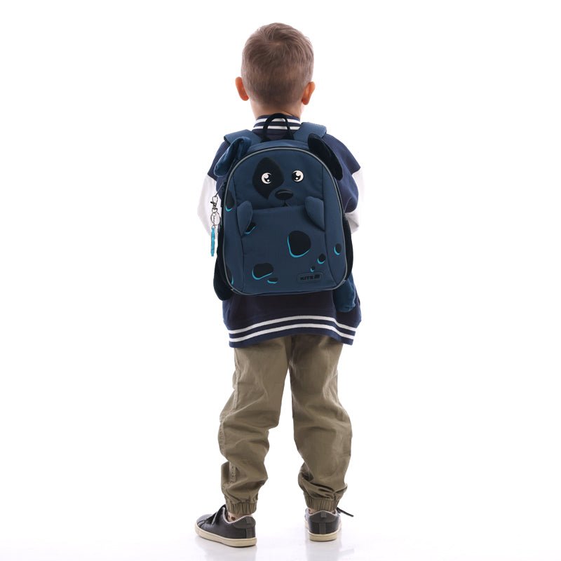 Kolorowy plecak Kite Kids K25-2728XS-2 z figlarnym designem i miękkimi ramiączkami w rękach malucha