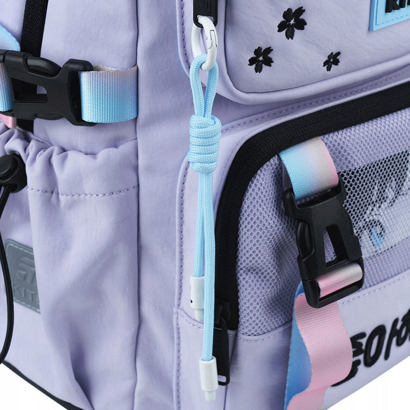 Zbliżenie na dekoracyjną podwieszkę (brelok) przy zamku plecaka.