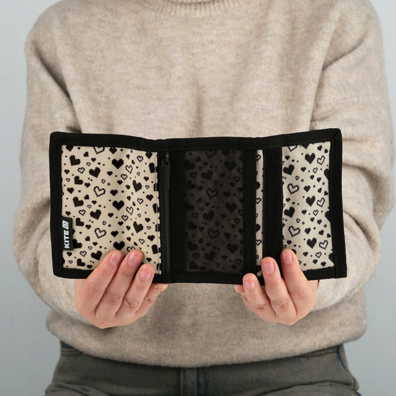 Portfel Kite z serduszkiem wygodnie leżący w dłoniach dziecka.