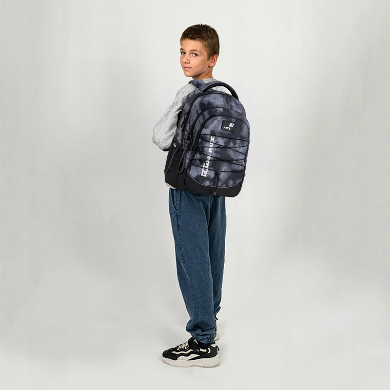 Profil chłopca z plecakiem prezentujący anatomiczne dopasowanie szelek S-kształtnych.