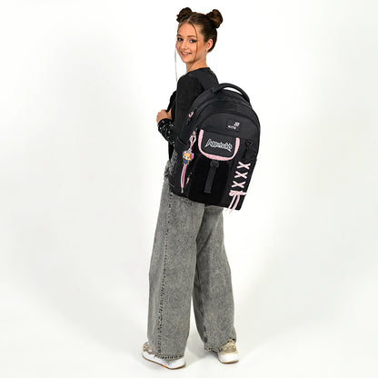 Nastolatka trzymająca stylowy czarny plecak na jednym ramieniu.