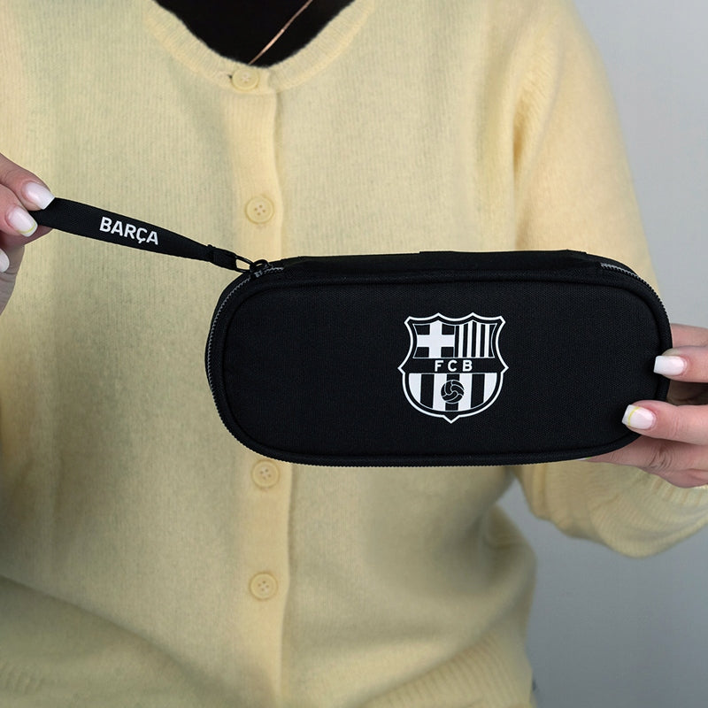 Zamknięty piórnik FC Barcelona trzymany w dłoniach.