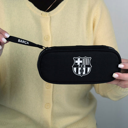 Zamknięty piórnik FC Barcelona trzymany w dłoniach.
