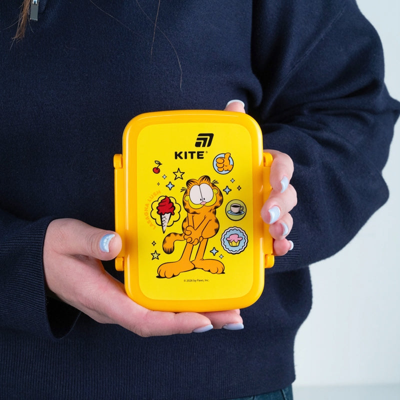 Mały snackbox Garfield trzymany w dłoniach dziecka.