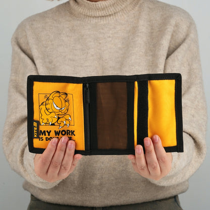 Portfel Kite Garfield w dłoniach dziecka podczas płacenia.