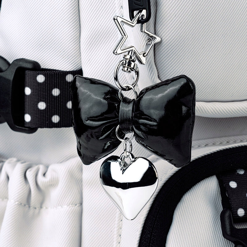 Zbliżenie na dekoracyjny brelok przy zamku plecaka.