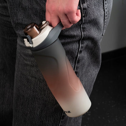 Bidon sportowy Kite trzymany za wygodny, zintegrowany uchwyt.