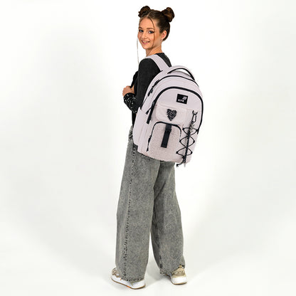 Modelka trzymająca jasnoróżowy plecak Kite na jednym ramieniu, prezentująca jego lekkość i swobodny styl.