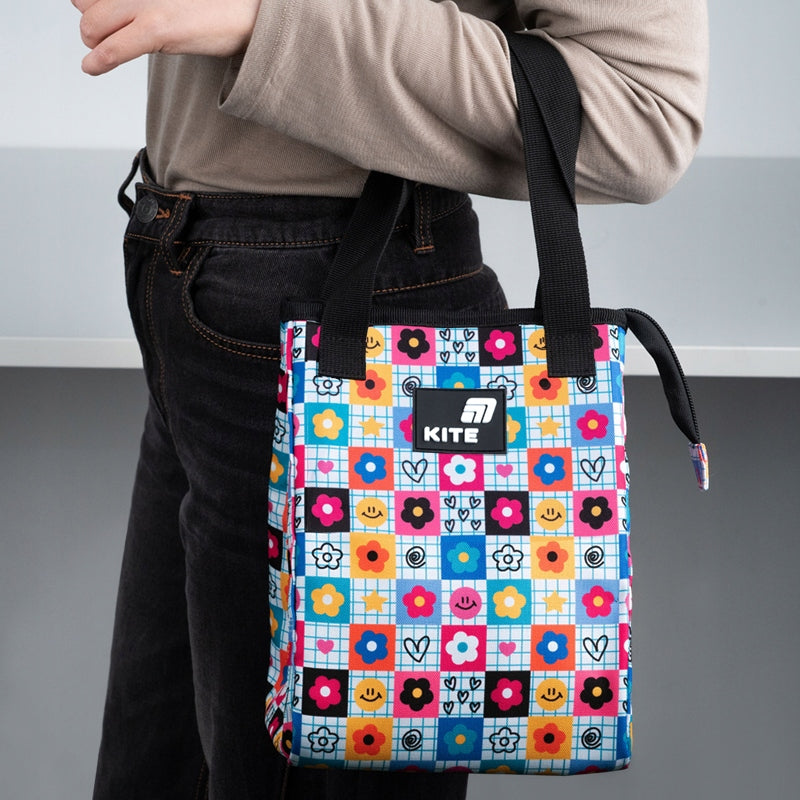 Osoba trzymająca kolorowy lunchbag Kite w dłoniach.