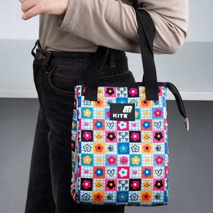 Osoba trzymająca kolorowy lunchbag Kite w dłoniach.
