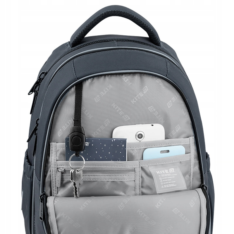 Otwarta kieszeń pokazująca uporządkowane miejsce na długopisy i pluszowy schowek na telefon.