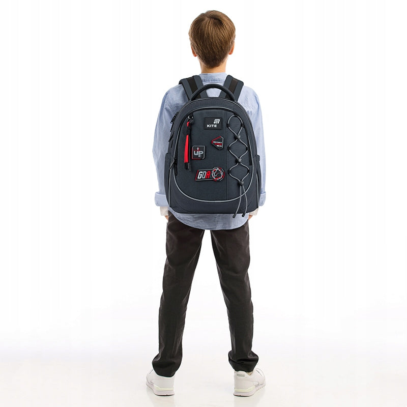 Plecak na plecach chłopca, widoczne dopasowanie szelek.