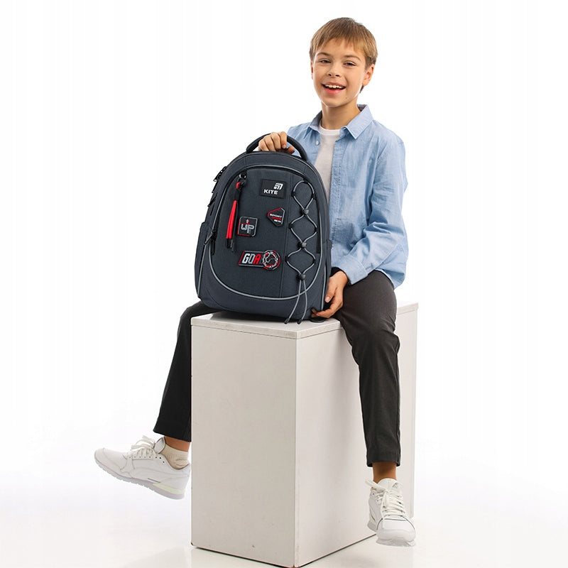 Widok dziecka stojącego obok plecaka Kite, prezentujący jego wielkość.