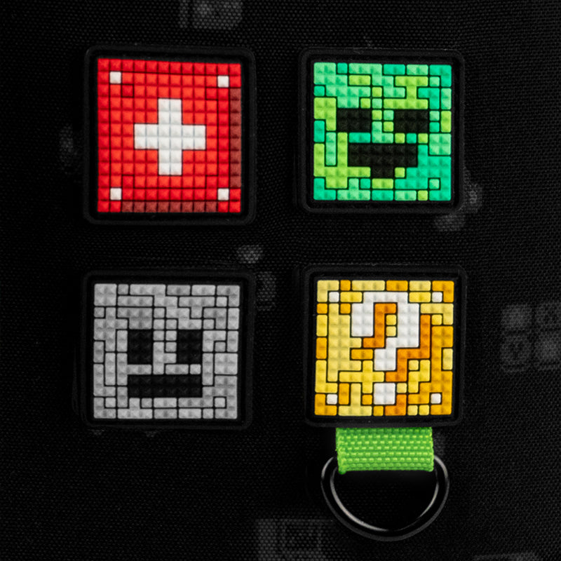 Frontowa strona czarnego plecaka Kite Minecraft z efektownymi gumowymi bejdżami i brelokiem z paracordu.