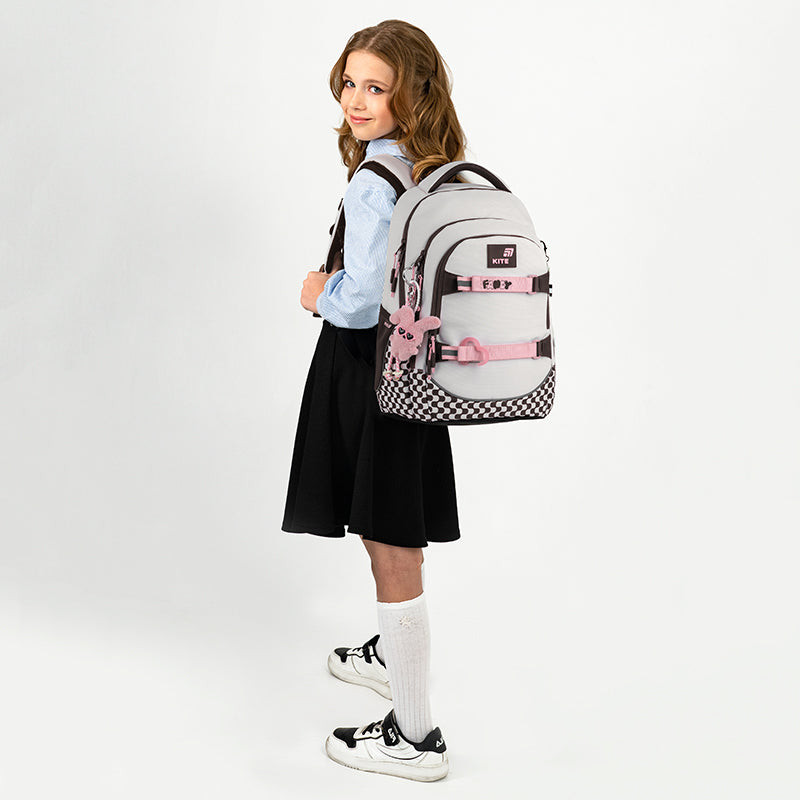 Beżowy plecak na plecach dziewczynki.