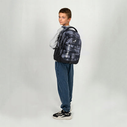 Profil chłopca z plecakiem prezentujący anatomiczne dopasowanie szelek S-kształtnych.