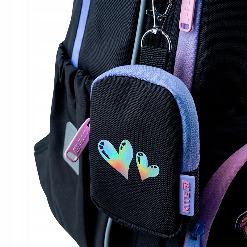 Odpinany fioletowy portfelik na karabińczyku przymocowany do plecaka.