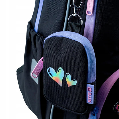 Odpinany fioletowy portfelik na karabińczyku przymocowany do plecaka.