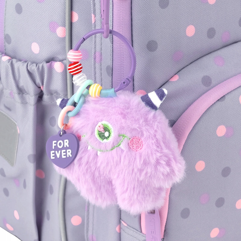 Puszysta zabawka-brelok przypięta do zamka plecaka Kite.