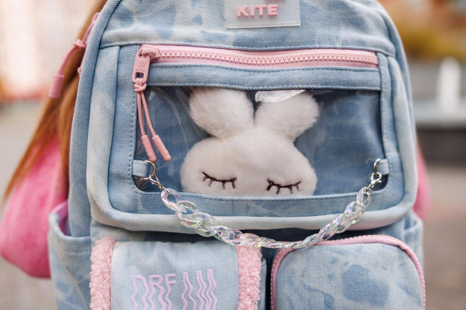 zabawka umieszczona w przezroczystej kieszeni plecaka Kite